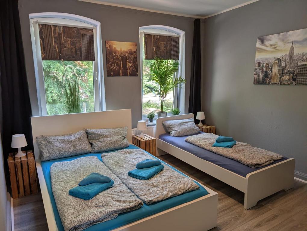 a bedroom with two beds and two windows at FördeNest in Flensburg