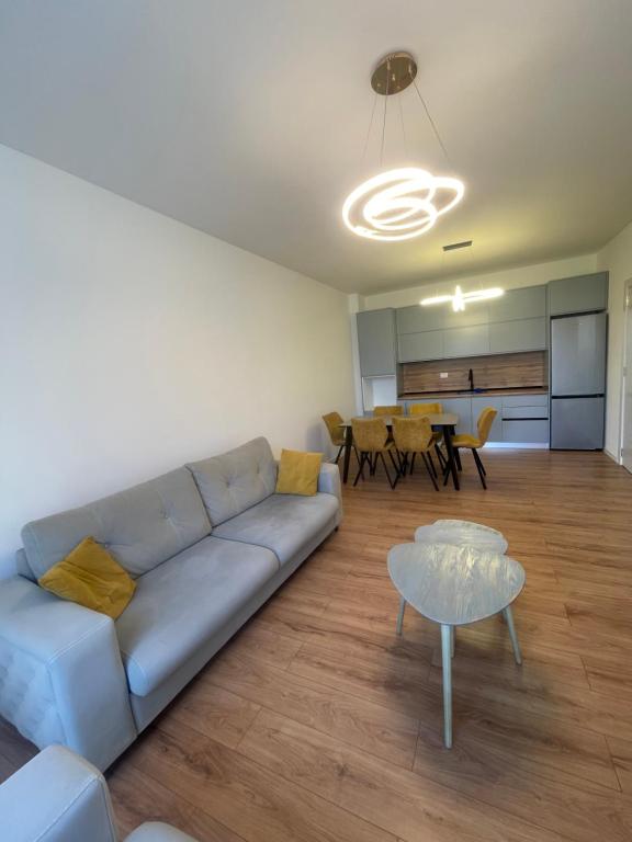 a living room with a blue couch and a table at Leni Apartment in Patza-Kuqani