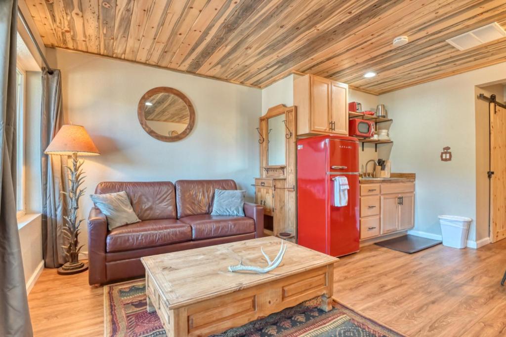 a living room with a couch and a red refrigerator at Fox Den Cozy Mountain Apt In GMF in Green Mountain Falls