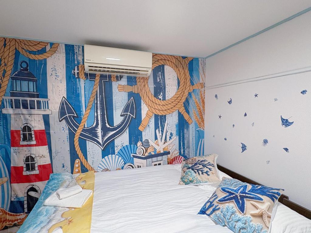 ein Schlafzimmer mit einem Bett und einem Wandgemälde an der Wand in der Unterkunft Yui HOSTEL in Tokio