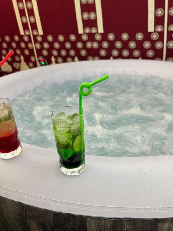 a drink sitting on a table next to a swimming pool at Wow Hotel Dakhla Gym, Free Jacuzzi & Breakfast Included in Dakhla