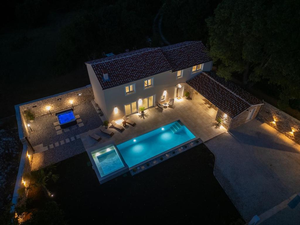 an overhead view of a house with a swimming pool at night at Villa de Pucci in Žminj