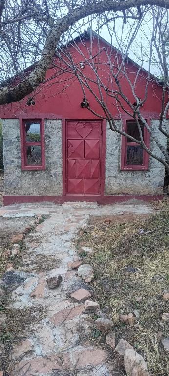 a red barn with a red door and two windows at Lebentera camp in Narok