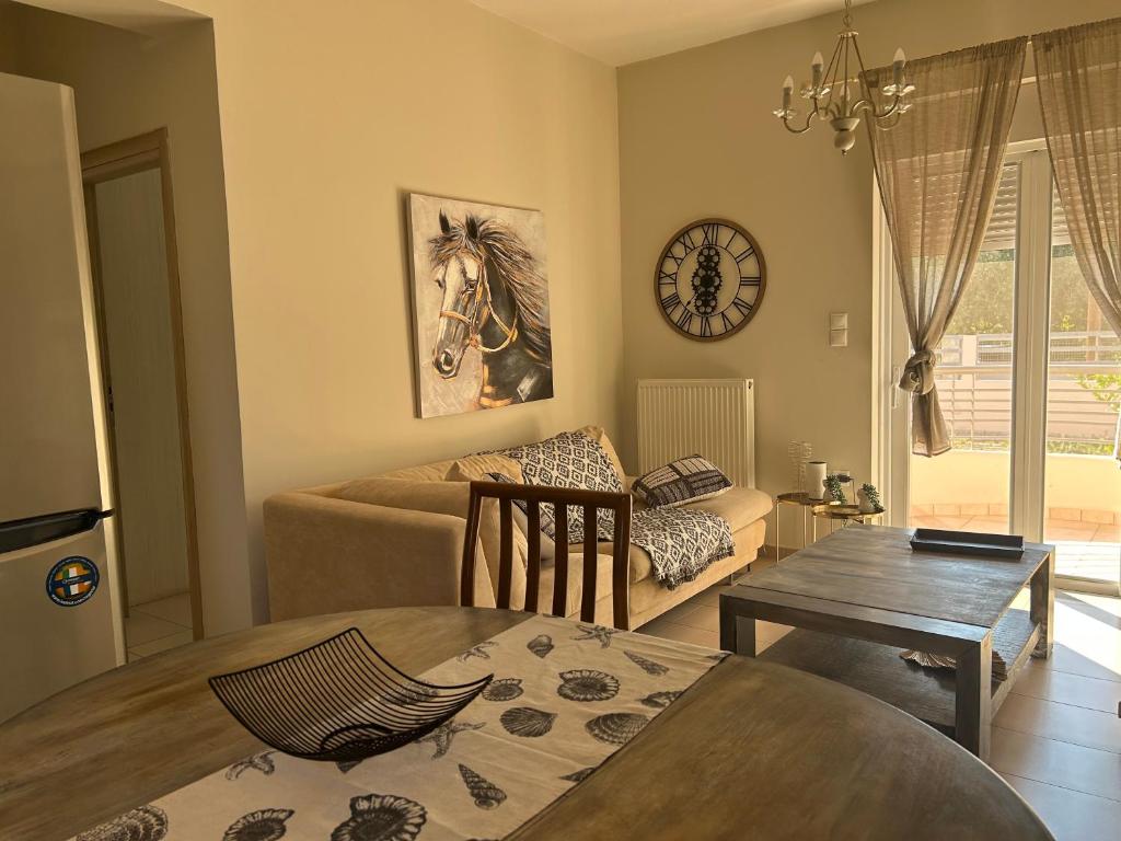 a living room with a table and a horse picture on the wall at Pearl kokkonaki in Kokóni