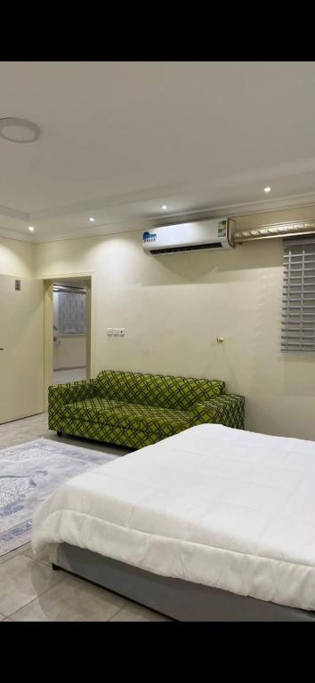 a bedroom with a large bed and a couch at hostel in Obhur in Jeddah