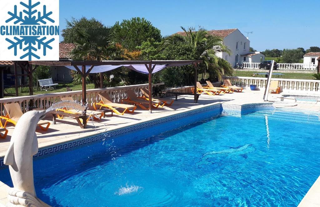 a swimming pool with chairs and a dolphin in the water at La Caleche in Bégadan