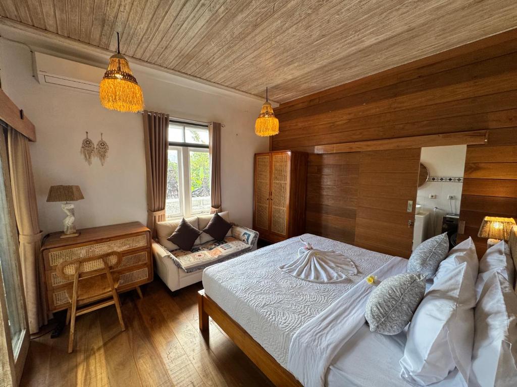 a bedroom with a large bed and a couch at Kanda Homestay in Sidemen