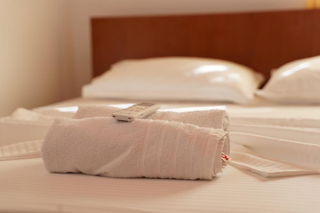 a remote control sitting on top of a bed at ARBERs aparthotel in Durrës