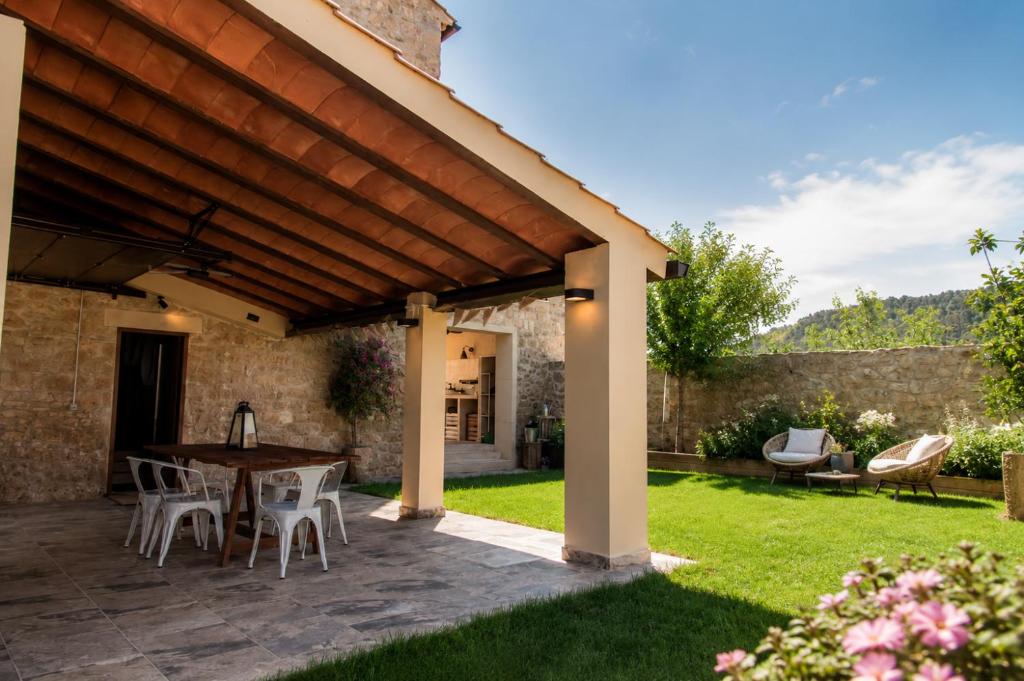 an outdoor patio with a wooden pergola at El Gresol - Naturaleza y Relax in Senant