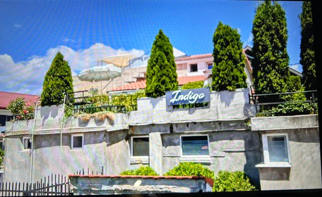 a building with trees and a sign on it at Apartmani BALKAN in Sjenica