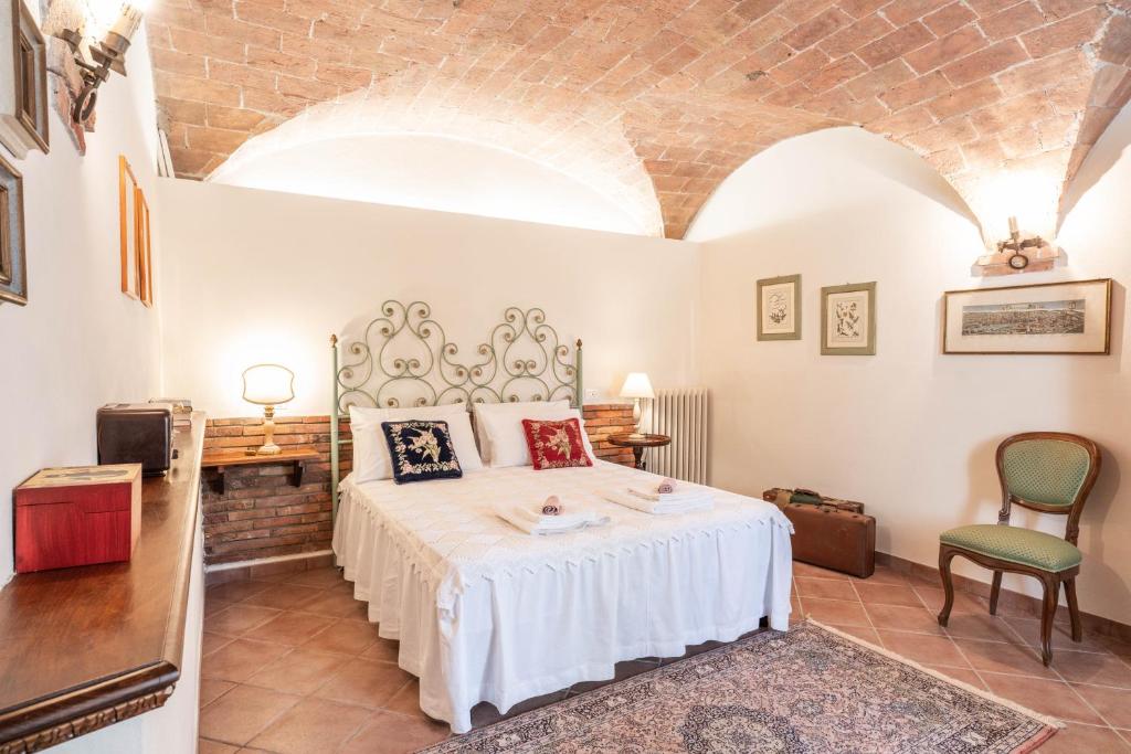 a bedroom with a bed and a chair in a room at Le ginestre 10 in Murlo