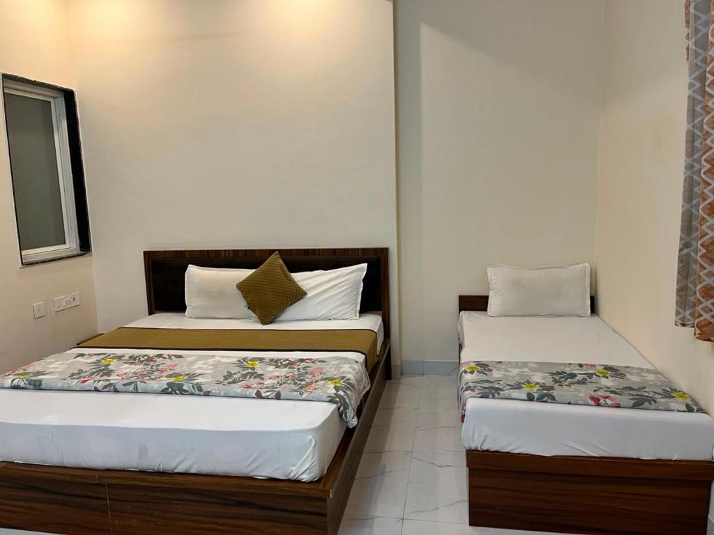two beds in a small room withermottermottermott at Hotel Banshi Wala - Best Hotel in Khatu Shyam ji Near Khatu shyam ji Tample in Khātu