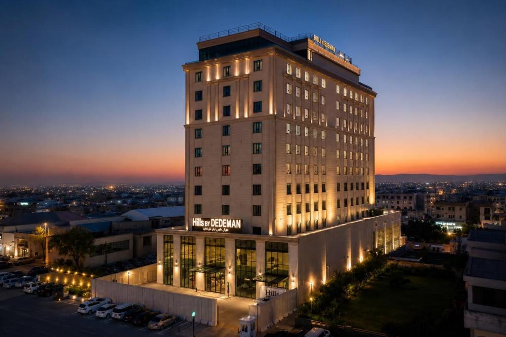 a tall building with lights on it at night at Hills Managed by Dedeman in Erbil