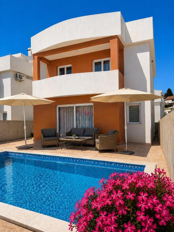 a villa with a swimming pool in front of a house at Villa Azar in Dobra Voda