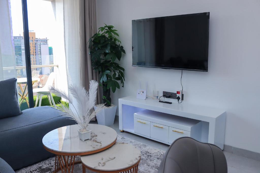 a living room with a couch and a tv on a wall at Meteor gardens in Nairobi