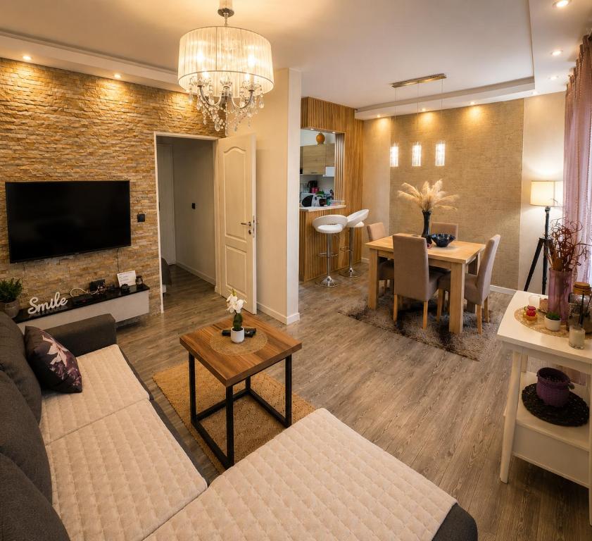 a living room with a couch and a dining room at New Moment in Žarkovo