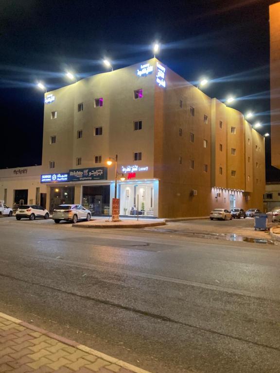 a large building on a city street at night at الكادي للشقق المخدومة in Ad Dawādimī