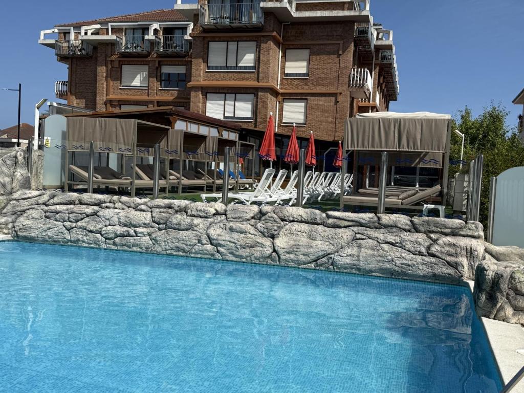 a swimming pool in front of a building at Hotel Gala in Noja