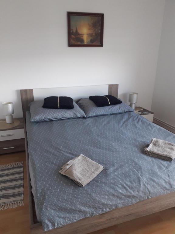 a bed with a blue comforter and two pillows at Noclegi u Beaty in Dubiecko