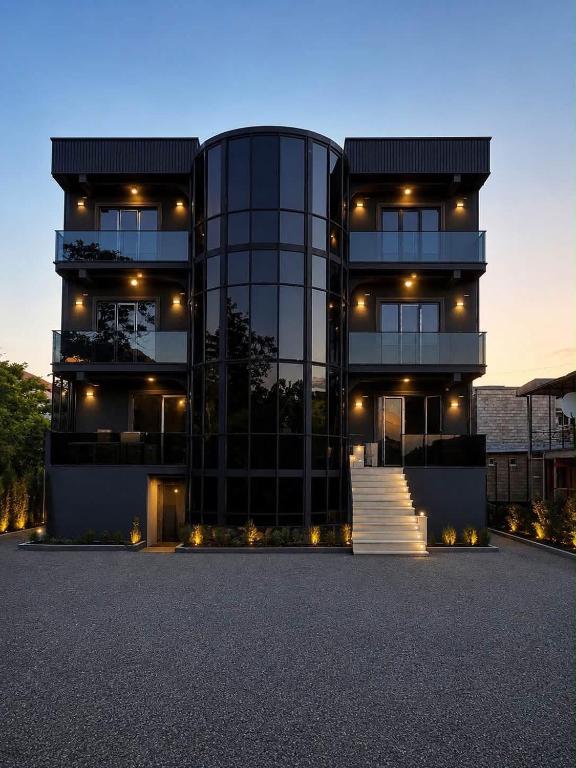 a large glass building with stairs in front of it at Our House in Kobuleti