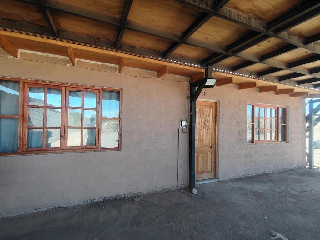 an empty room with a door and windows at Casa Atitur in San Pedro de Atacama