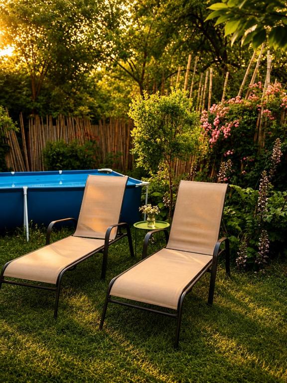 two chairs and a table in a yard with a pool at Guest House Germani in Telavi