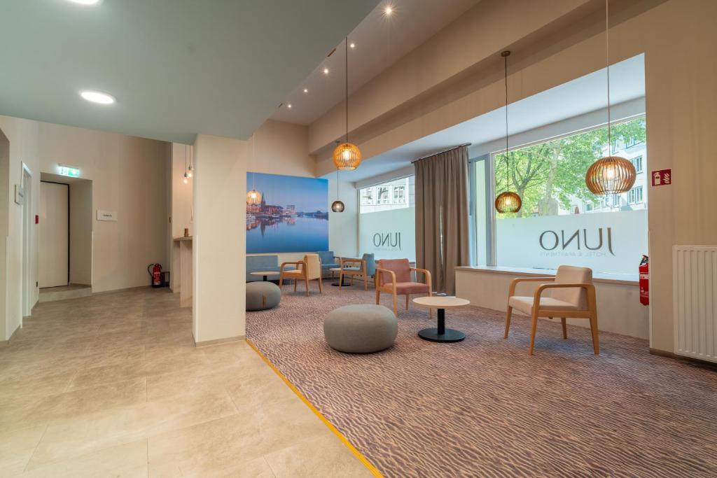 a waiting room with chairs and tables in a building at Juno Hotel Bremen City in Bremen