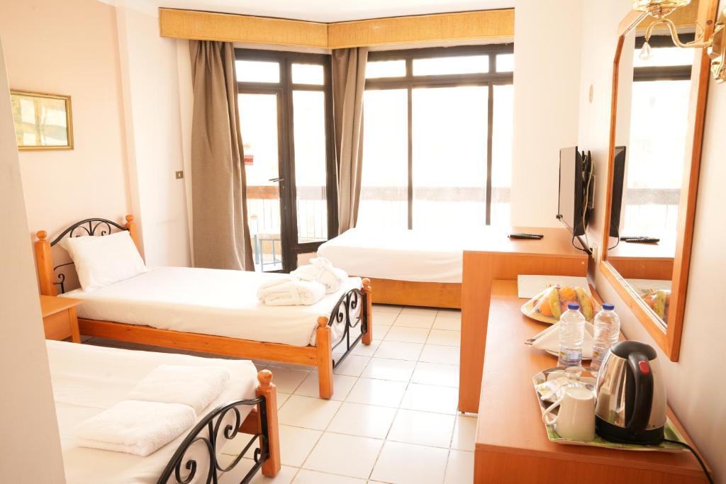 a hotel room with two beds and a television at Gaddis Hotel, Suites and Apartments in Luxor