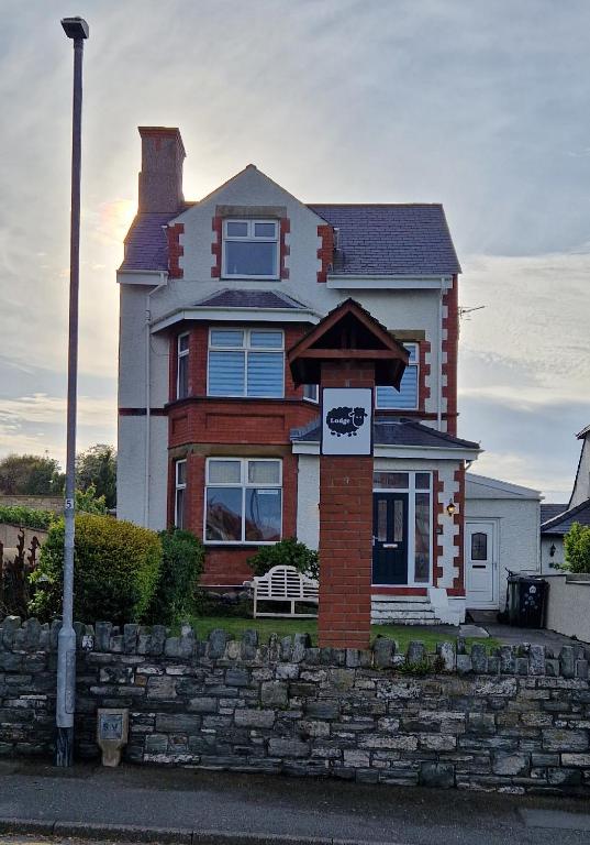 a house with a sign in front of it at Black Sheep Lodge in Holyhead
