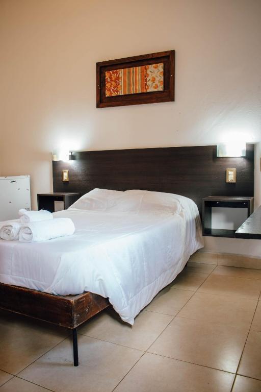 a bedroom with a large bed with white sheets at Hotel Del Parque in Corrientes