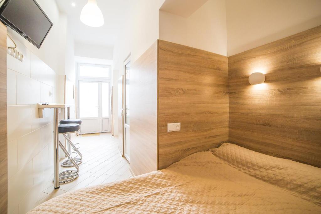 リヴィウにあるApartment on Kulisha 29-аの木製の壁のベッドルーム1室(ベッド1台付)