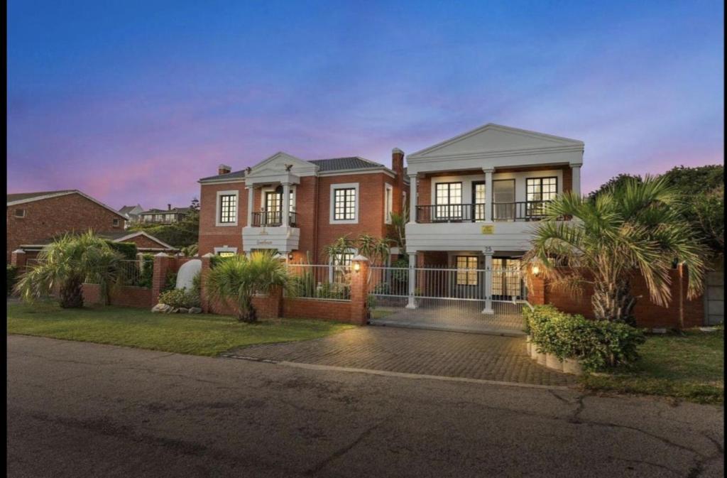 a large brick house with palm trees in front of it at ACRE on Albatros in Gqeberha