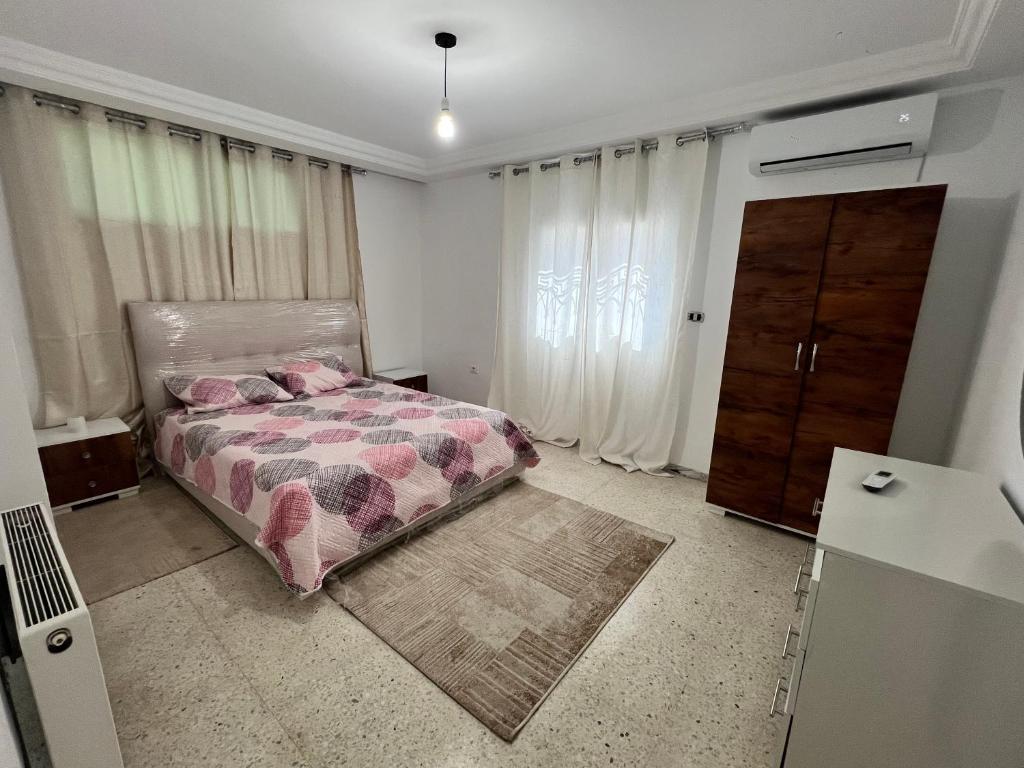 a bedroom with a bed and a dresser at Appartement 2 chambres à 250m de la plage, propre & bien équipé in Monastir