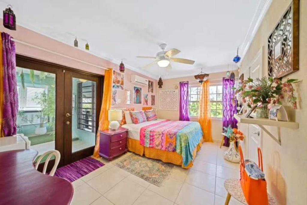 a bedroom with a bed and a table and a ceiling fan at Hidden Gem The Moroccan - by ZenBreak in Christ Church