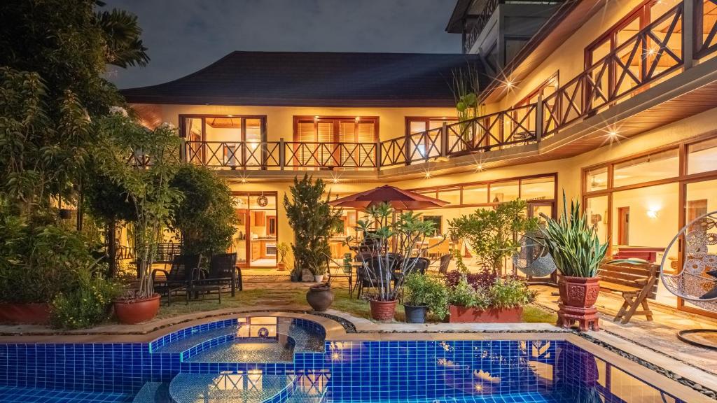 a house with a swimming pool in front of it at Orchid House Pattaya, Totally Private Pool in Pattaya South