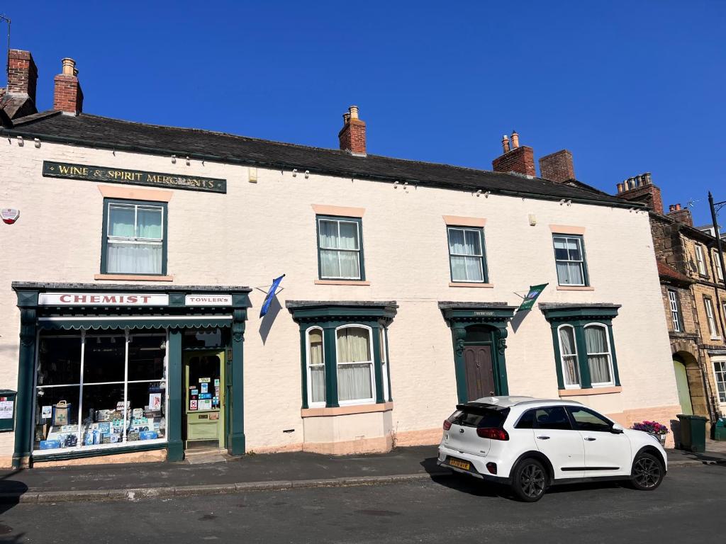 a white car parked in front of a building at Towler's Chemist in Kirkbymoorside