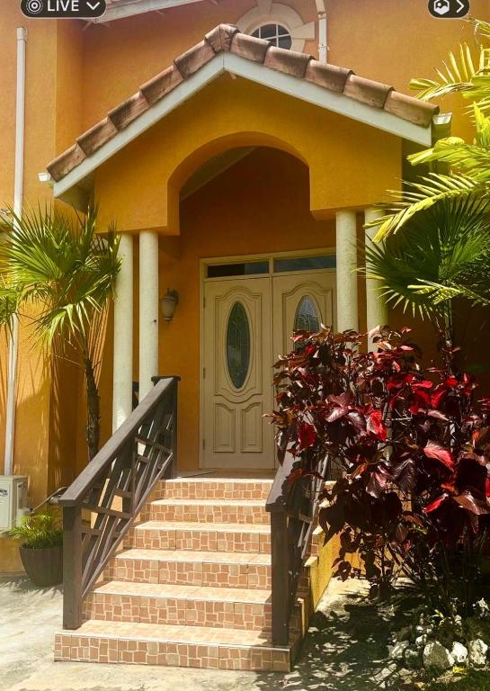 a yellow house with stairs leading to a door at Cazuria - by ZenBreak in Saint George