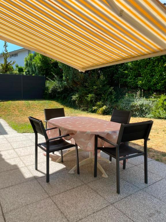 a table and two chairs under an orange umbrella at Villa dolce vita in Murten