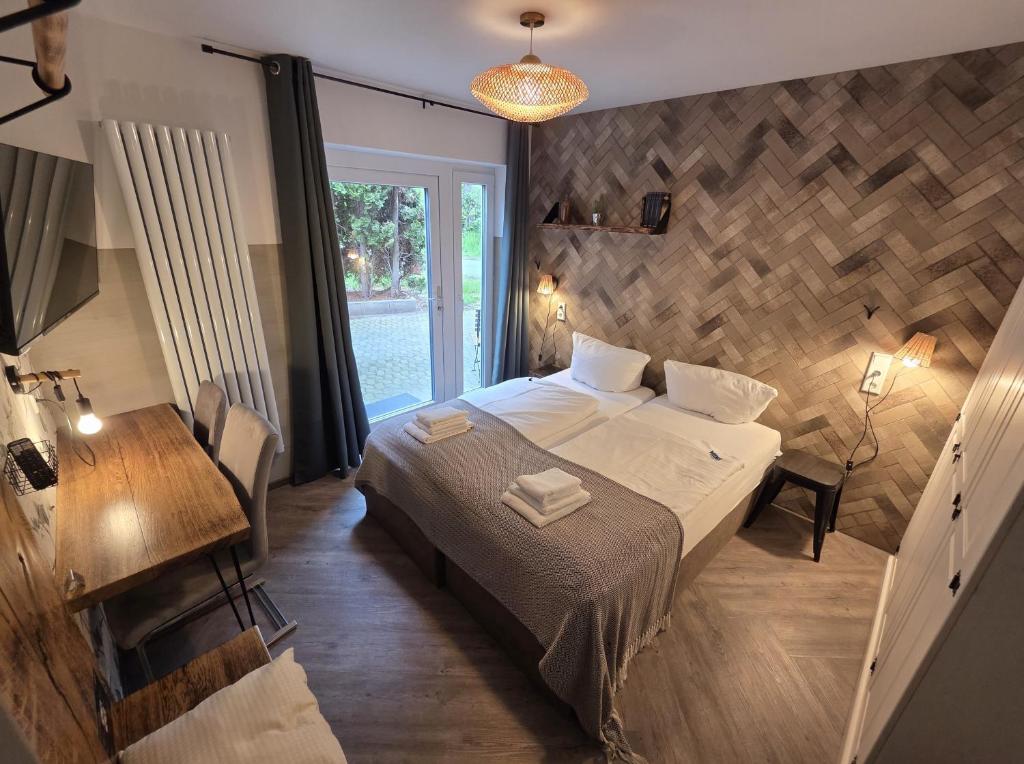 a bedroom with a bed and a table and a window at Aparthotel Fairschlafen Minden in Minden