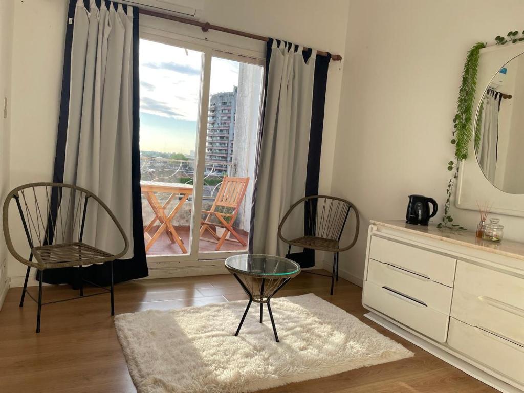 a living room with two chairs and a glass table at Hotel Plaza in Concepción del Uruguay