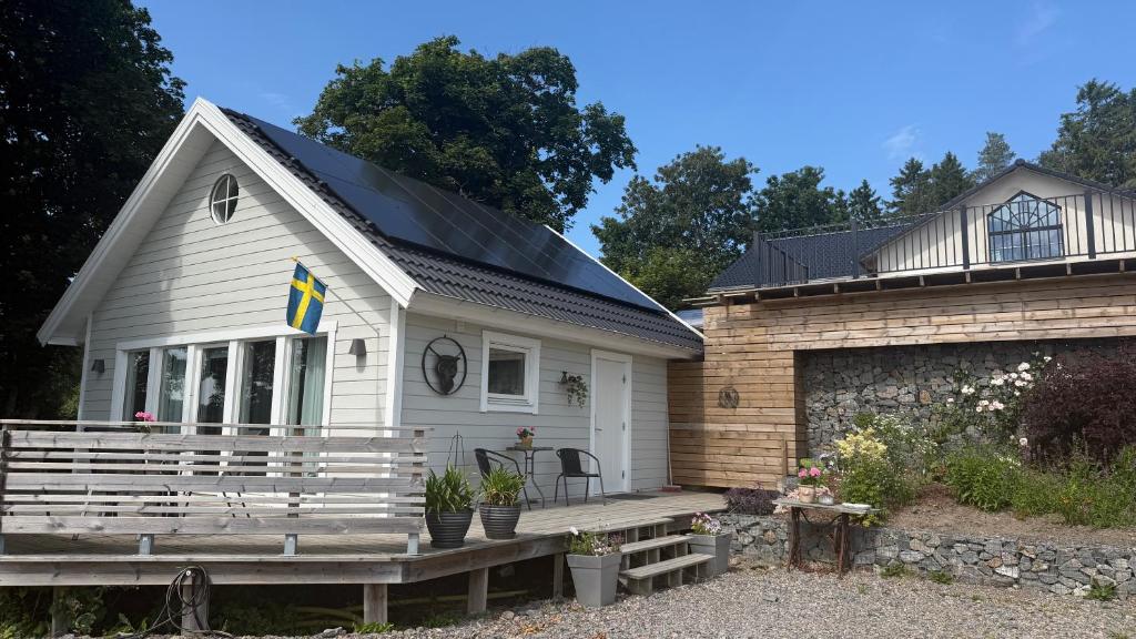 a white house with a porch and a building at Reinholds Gästhus in Kareby