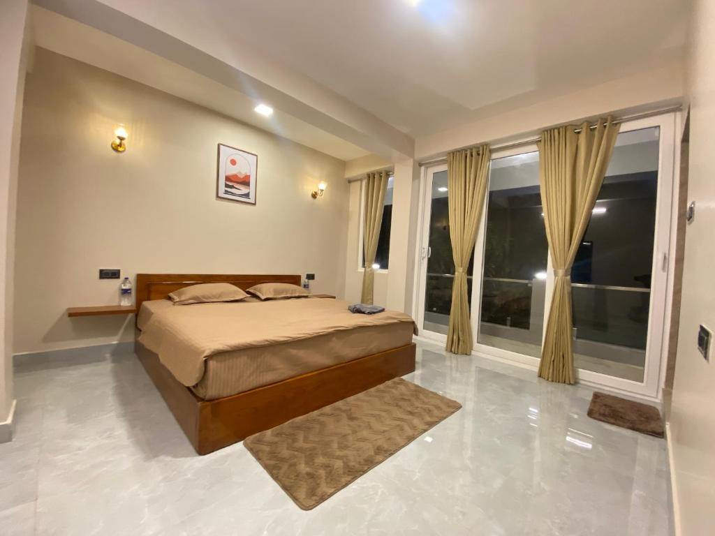 a bedroom with a bed and a large window at Stayat77 in Karsiyang