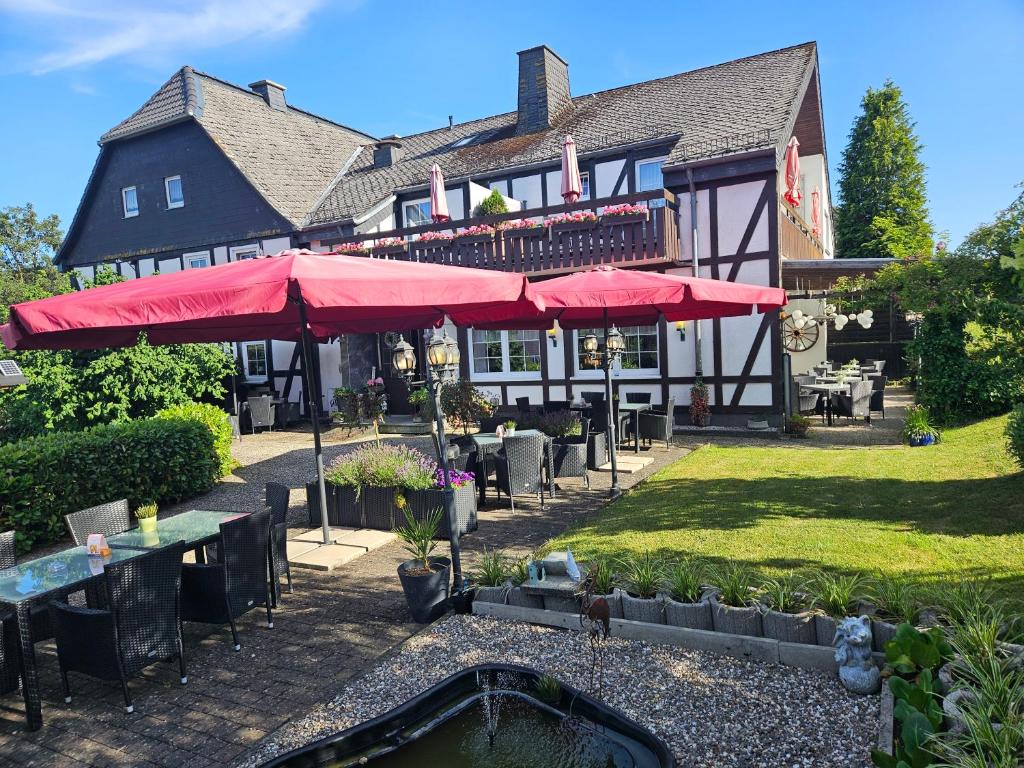 a restaurant with tables and umbrellas in front of it at Hennetaler Hof in Erflinghausen