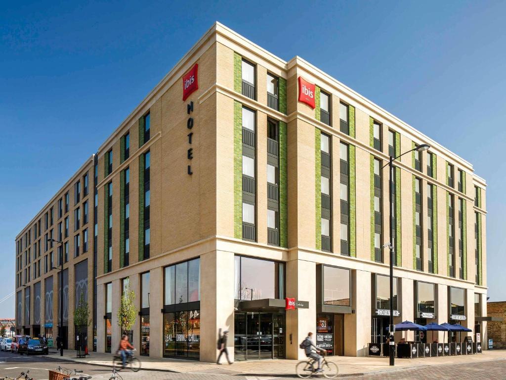 a large building with people riding bikes in front of it at ibis Cambridge Central Station in Cambridge