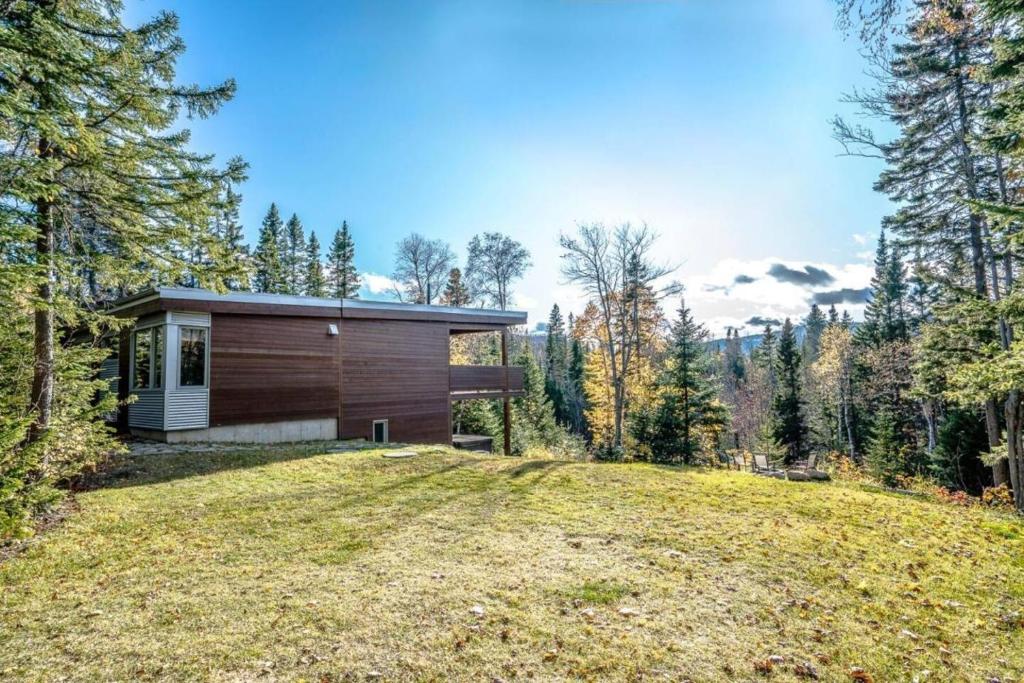 a house in the woods with a large yard at Welcome to La Cabine de Charlevoix in Petite-Rivière-Saint-François