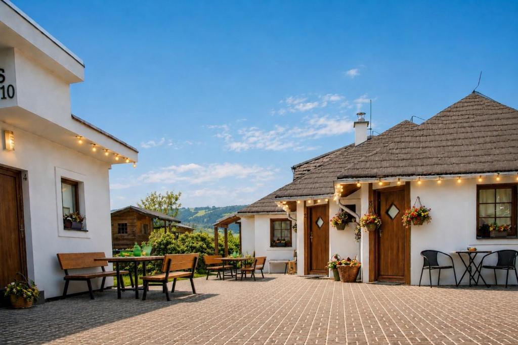 a patio of a house with tables and chairs at Piemonti Bešeňová in Bešeňová