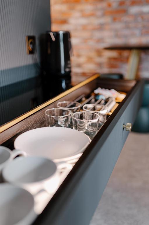 a counter with white plates and glasses on it at Apartamenty Wieliczka in Wieliczka