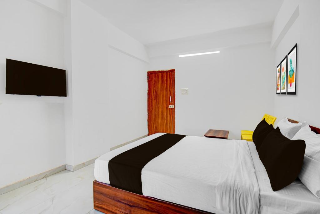 a bedroom with a bed and a tv on a wall at Super Hotel O Destiny Inn in Pune