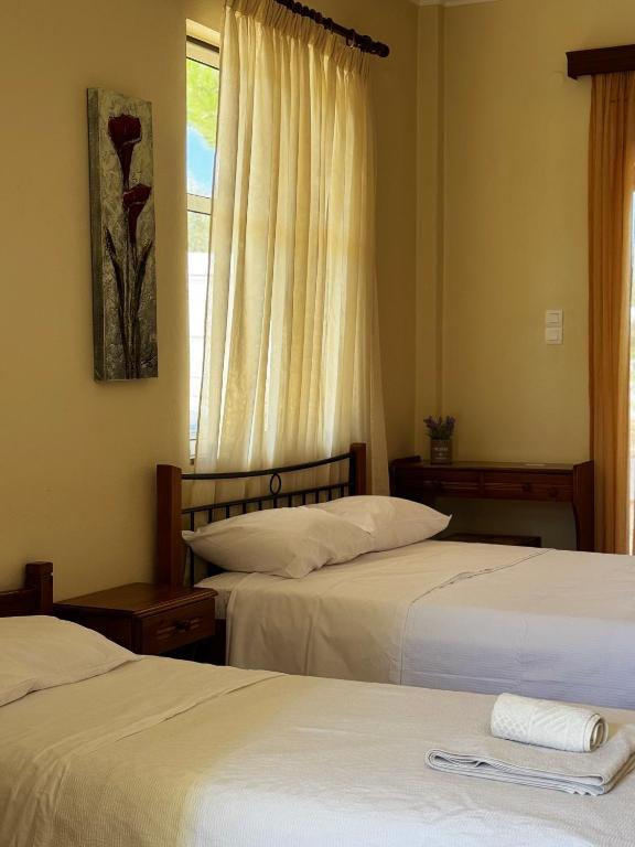 zwei Betten in einem Hotelzimmer mit Fenster in der Unterkunft Karfas Hideaway in Karfás