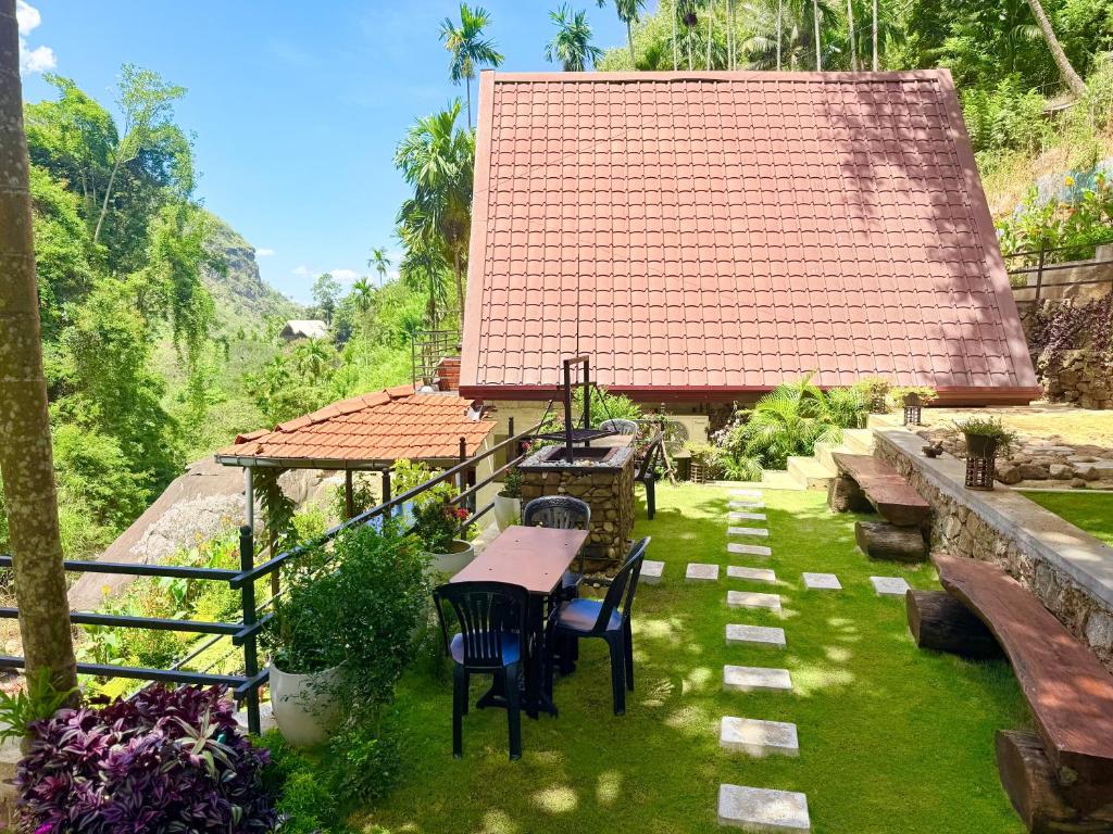 a patio with a table and chairs in a yard at Cinnamon River Cabana in Ella